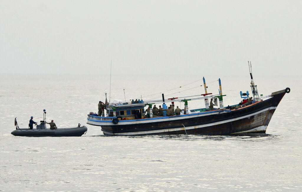 In this photo released by the U.S. Navy, U.S. service members from coastal patrol ship USS Tempest (PC 2) and USS Typhoon (PC 5) approach a stateless dhow vessel carrying illicit drugs while transiting international waters in the Arabian Sea, Dec. 27, 2021. United States navy vessels seized 385 kilograms (849 pounds) of heroin in the Arabian Sea worth some $4 million in a major bust by the international maritime operation in the region, officials said Thursday, Dec. 30, 2021. (U.S. Navy photo via AP)