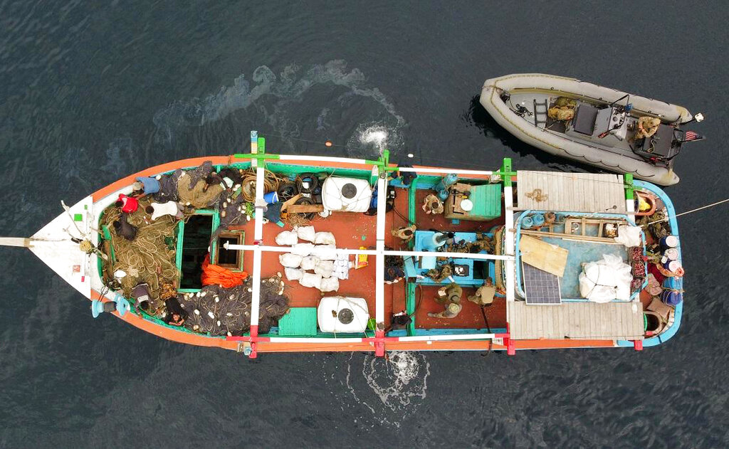 In this aerial photo released by the U.S. Navy, U.S. service members from coastal patrol ship USS Tempest (PC 2) and USS Typhoon (PC 5) inventory an illicit shipment of drugs while aboard a stateless dhow vessel transiting international waters in the Arabian Sea, Dec. 27, 2021. United States navy vessels seized 385 kilograms (849 pounds) of heroin in the Arabian Sea worth some $4 million in a major bust by the international maritime operation in the region, officials said Thursday. (U.S. Navy photo Via AP)