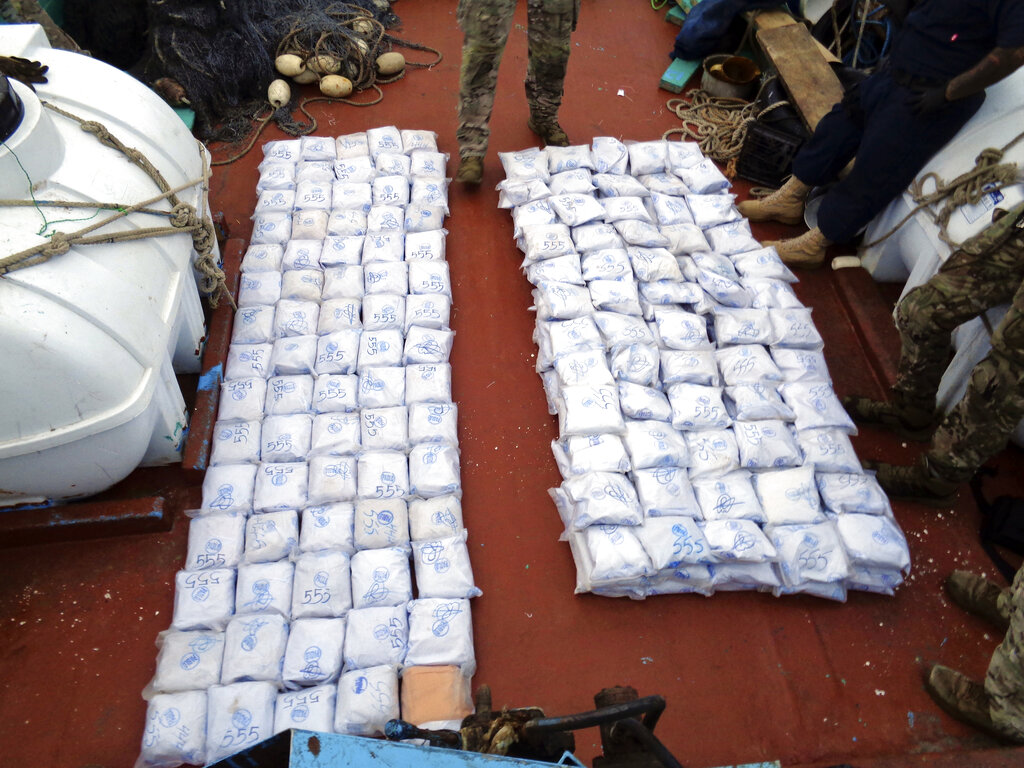 In this photo released by the U.S. Navy, U.S. service members from coastal patrol ship USS Tempest (PC 2) and USS Typhoon (PC 5) gather confiscated illegal drugs aboard a stateless dhow vessel apprehended while transiting international waters in the Arabian Sea, Dec. 27, 2021. United States navy vessels seized 385 kilograms (849 pounds) of heroin in the Arabian Sea worth some $4 million in a major bust by the international maritime operation in the region, officials said Thursday, Dec. 30, 2021. (U.S. Navy photo via AP)