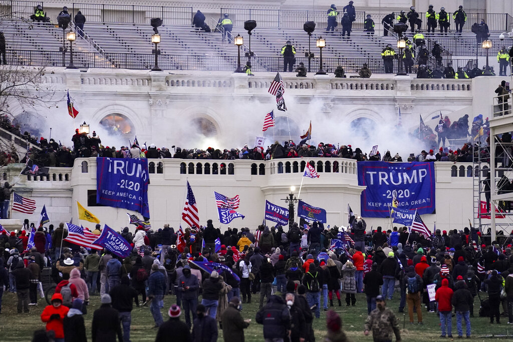 FILE - In this Jan. 6, 2021, file photo, violent protesters, loyal to then-President Donald Trump, storm the Capitol, Wednesday, Jan. 6, 2021, in Washington. Two Seattle police officers who were in Washington, D.C., during the January 6 insurrection were illegally trespassing on Capitol grounds while rioters stormed the building, but lied about their actions, a police watchdog said in a report released Thursday, July 8, 2021. (AP Photo/John Minchillo, File)