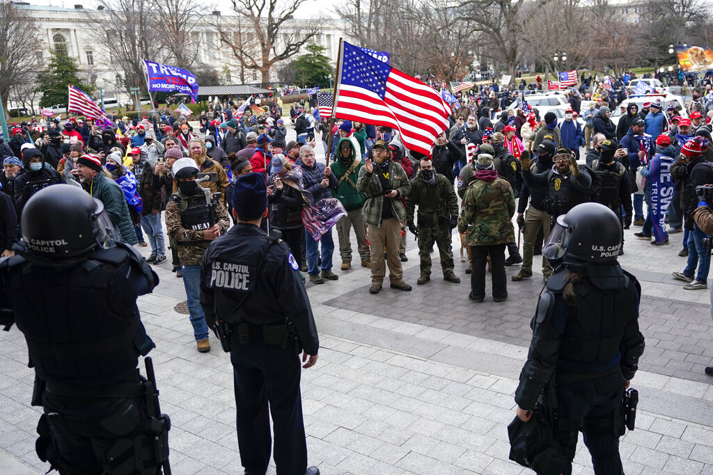 U.S. Capitol Police officers stand outside a door on the Senate side of the U.S. Capitol as rioters storm the capitol on Jan. 6, 2021, in Washington.  (AP Photo/Manuel Balce Ceneta)