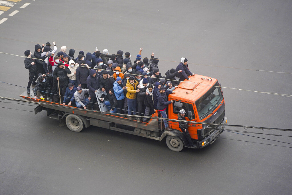 Demonstrators ride a truck during a protest in Almaty, Kazakhstan, Wednesday, Jan. 5, 2022. Demonstrators denouncing the doubling of prices for liquefied gas have clashed with police in Kazakhstan's largest city and held protests in about a dozen other cities in the country. (AP Photo/Vladimir Tretyakov)