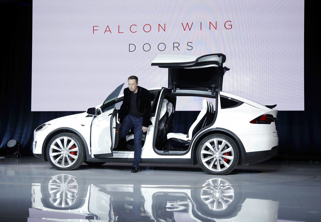 Elon Musk, CEO of Tesla Motors Inc., introduces the Model X car at the company's headquarters Tuesday, Sept. 29, 2015, in Fremont, Calif. Musk said the Model X sets a new bar for automotive engineering, with unique features like rear falcon-wing doors, which open upward, and a driver's door that opens on approach and closes itself when the driver is inside. (AP Photo/Marcio Jose Sanchez)