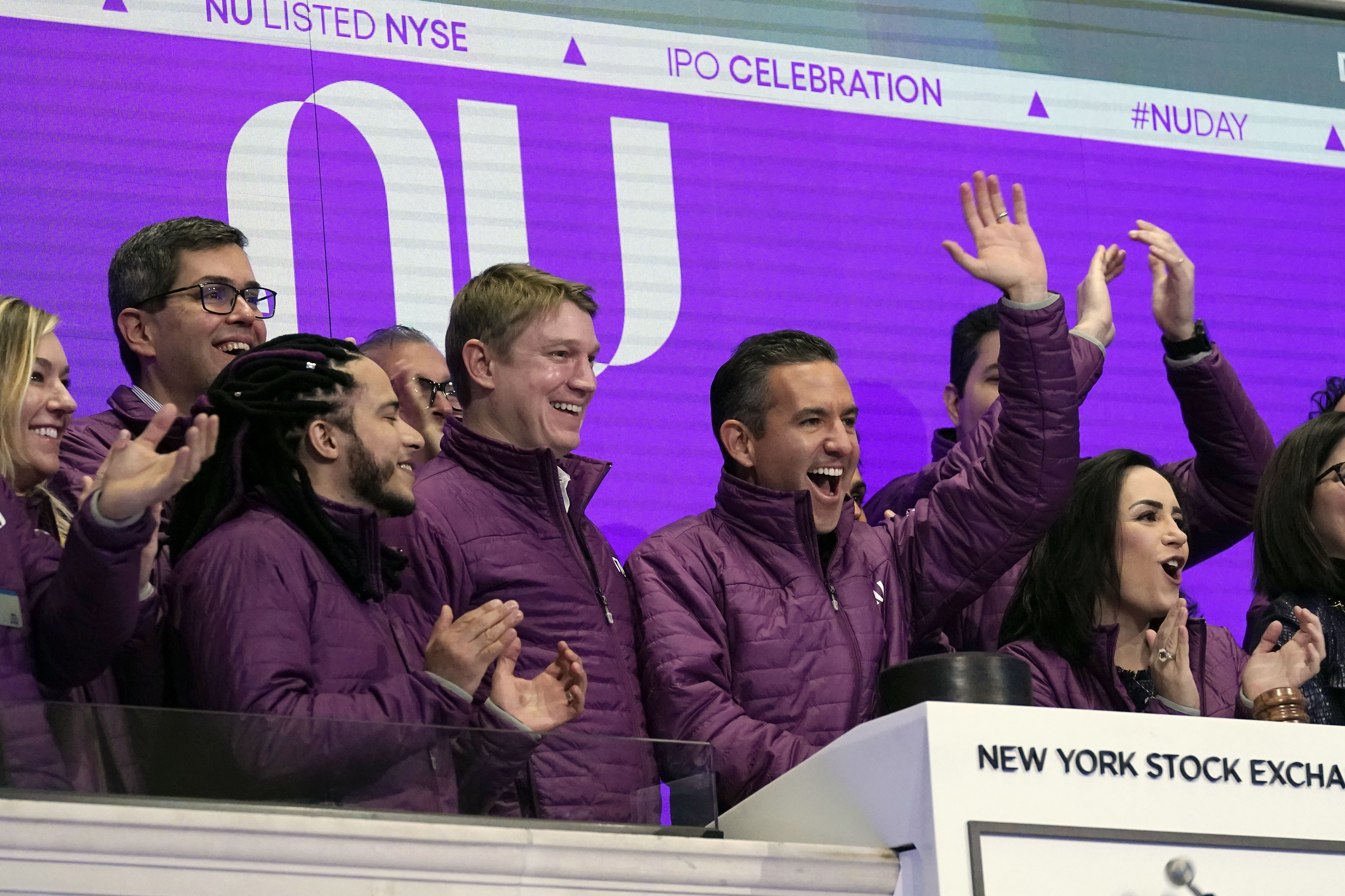Nubank CEO David Velez, second from right, is flanked by co-Founders Edward Wible, third from right, and Cristina Junqueira, right, as he rings the New York Stock Exchange opening bell, before their company's IPO, Thursday, Dec. 9, 2021. (AP Photo/Richard Drew)