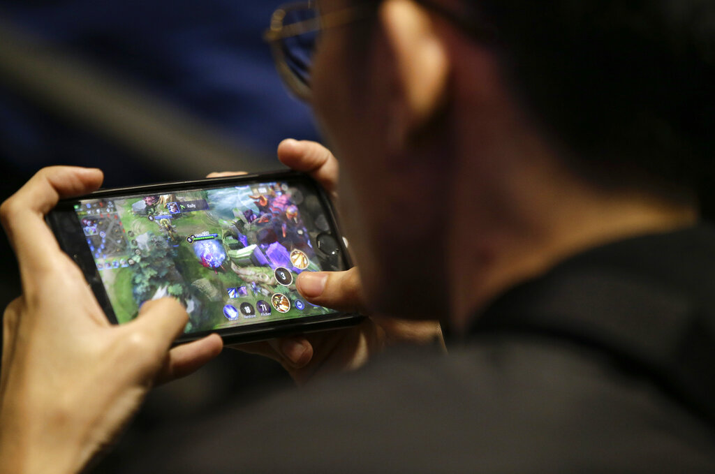 In this Thursday, Aug. 29, 2019, photo, an esport (electronic sport) player plays on his smartphone during the qualifying rounds for the first Philippine esport team in metropolitan Manila, Philippines. Esports, a form of competition using video games, will be making its debut as a medal sport at the 30th South East Asian Games in the country which starts November this year. (AP Photo/Aaron Favila)