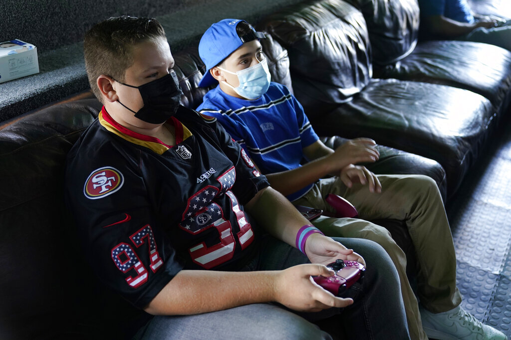 Fans play video games inside the Game Truck before a preseason NFL football game between the Los Angeles Chargers and the San Francisco 49ers Sunday, Aug. 22, 2021, in Inglewood, Calif. (AP Photo/Ashley Landis)