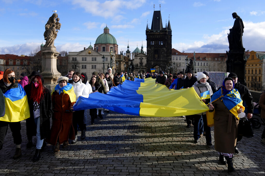 Supporters of Ukraine carry a large Ukrainian flag on the medieval Charles Bridge in Prague, Czech Republic, Saturday, Jan. 22, 2022. Several dozens of people gathered to show their allegiance with the country during heightened tensions with Russia. (AP Photo/Petr David Josek)