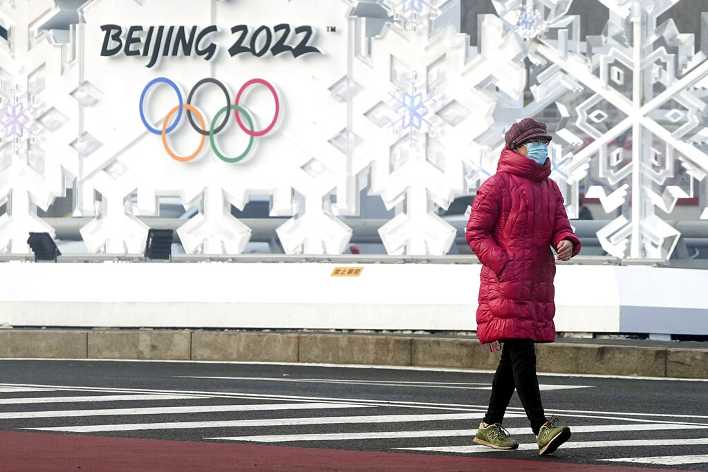 A woman walks near the Olympic Park at the 2022 Winter Olympics, Tuesday, Jan. 25, 2022, in Beijing, China. (AP Photo/David J. Phillip)