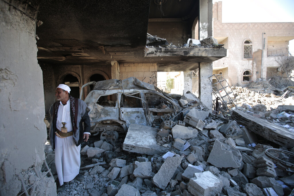 A man inspects the wreckage of a building after it was damaged in Saudi-led coalition airstrikes, in Sanaa, Yemen, Tuesday, Jan. 18, 2022. The coalition fighting in Yemen announced it had started a bombing campaign targeting Houthi sites a day after a fatal attack on an oil facility in the capital of the United Arab Emirates claimed by Yemen’s Houthi rebels. It said it also struck a drone operating base in Nabi Shuaib Mountain near Sanaa. (AP Photo/Hani Mohammed)