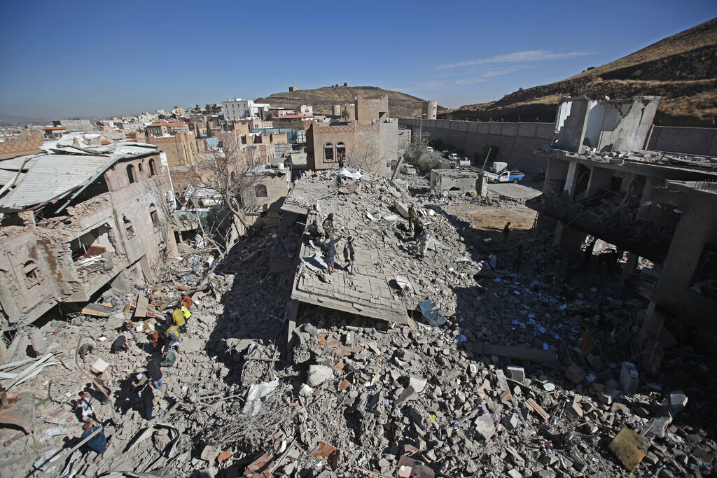 People inspect the wreckage of buildings after they were damaged by Saudi-led coalition airstrikes, in Sanaa, Yemen, Tuesday, Jan. 18, 2022. The coalition fighting in Yemen announced it had started a bombing campaign targeting Houthi sites a day after a fatal attack on an oil facility in the capital of the United Arab Emirates claimed by Yemen’s Houthi rebels. It said it also struck a drone operating base in Nabi Shuaib Mountain near Sanaa. (AP Photo/Hani Mohammed)