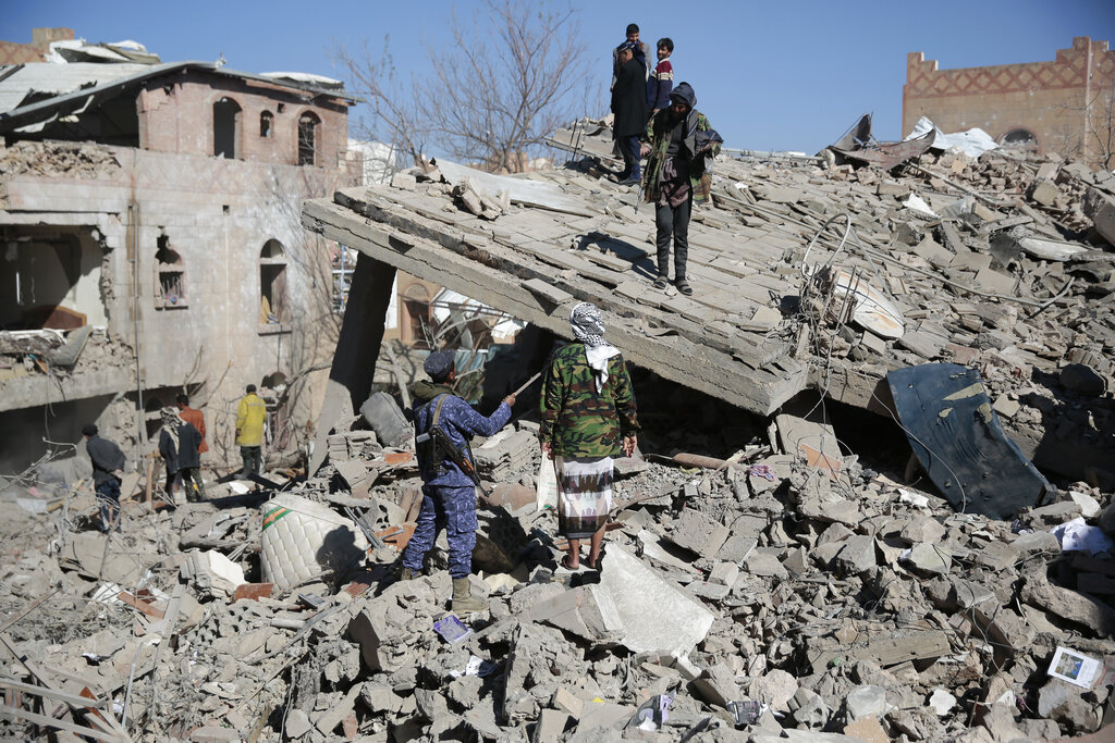 People inspect the wreckage of buildings that were damaged by Saudi-led coalition airstrikes, in Sanaa, Yemen, Tuesday, Jan. 18, 2022. The coalition fighting in Yemen announced it had started a bombing campaign targeting Houthi sites a day after a fatal attack on an oil facility in the capital of the United Arab Emirates claimed by Yemen’s Houthi rebels. It said it also struck a drone operating base in Nabi Shuaib Mountain near Sanaa. (AP Photo/Hani Mohammed)