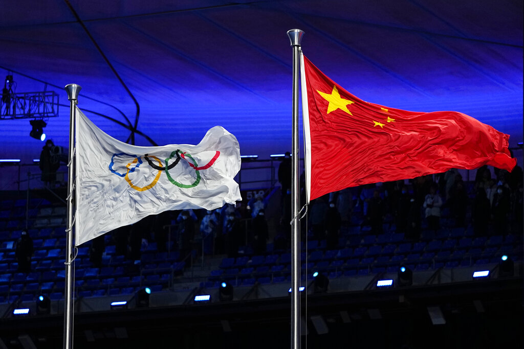 The Chinese and Olympic flags fly during the opening ceremony of the 2022 Winter Olympics, Friday, Feb. 4, 2022, in Beijing. (AP Photo/Jae C. Hong)
