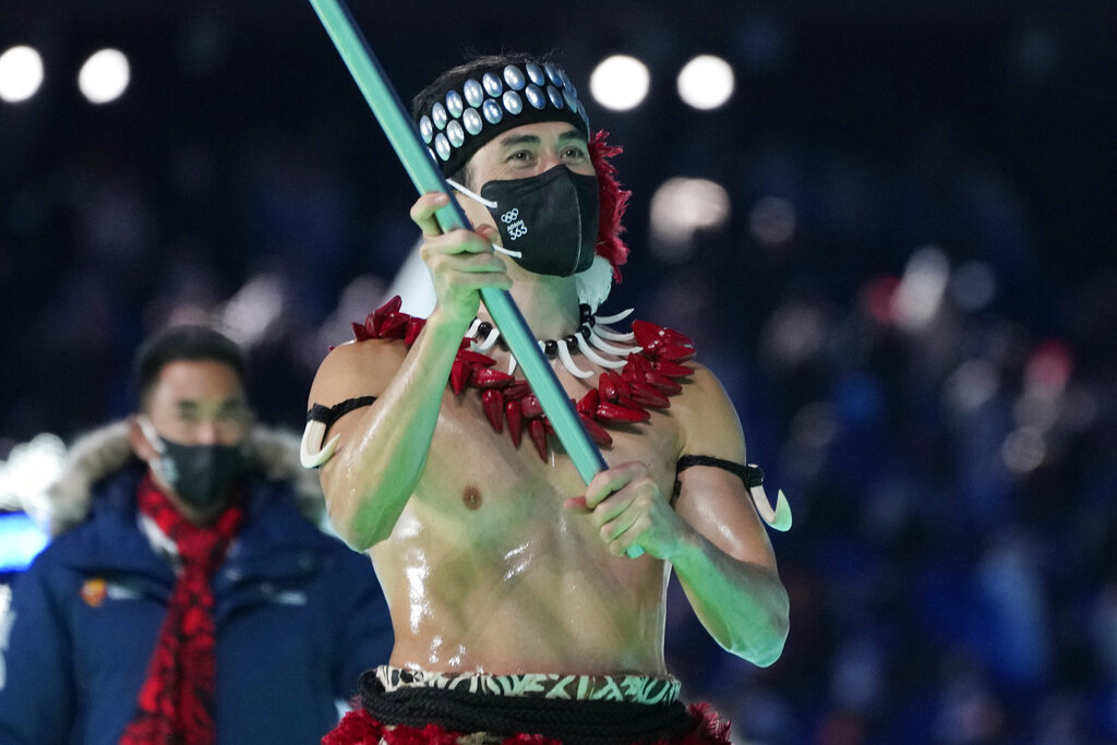 Nathan Crumpton, of American Samoa, carries his national flag into the stadium during the opening ceremony of the 2022 Winter Olympics, Friday, Feb. 4, 2022, in Beijing. (AP Photo/Natacha Pisarenko)
