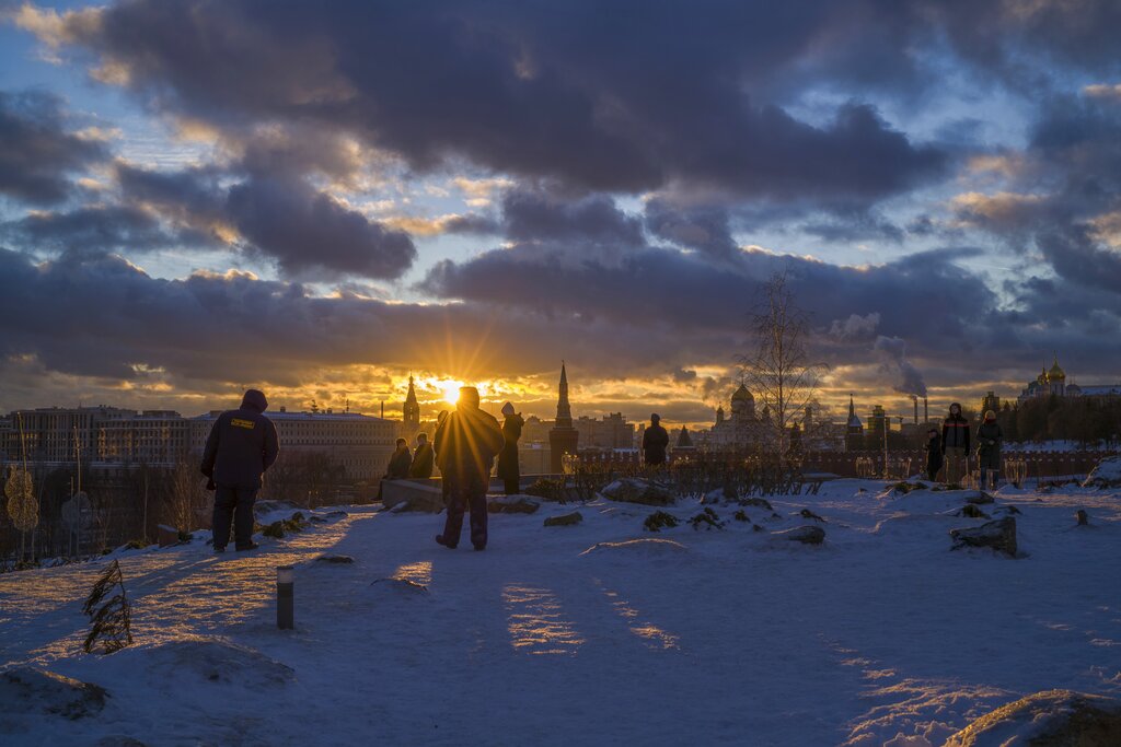People watch the sunset over the Kremlin, at Zaryadye Park in Moscow, Russia, Sunday, Jan. 16, 2022. (AP Photo/Yuri Degtyarev)