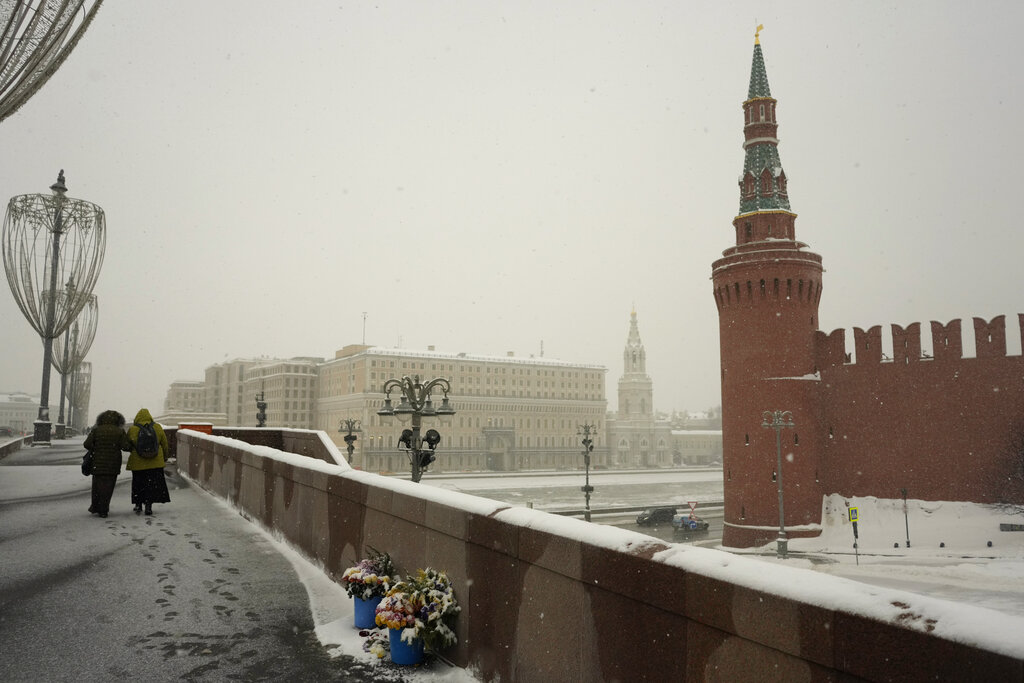 Women walk past the bunches of flowers laid near the place where Russian opposition leader Boris Nemtsov was gunned down, on the Bolshoy Moskvoretsky Bridge, in Moscow, Russia, Monday, Feb. 7, 2022. (AP Photo/Thibault Camus)