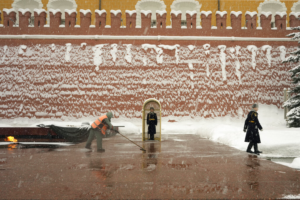 A worker removes snow from the Tomb of the Unknown Soldier, in Moscow, Russia, Monday, Feb. 7, 2022. (AP Photo/Thibault Camus)