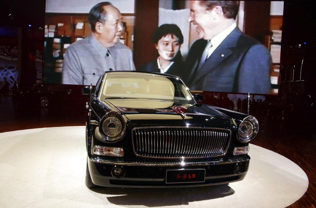 In this April 21, 2013 photo, the top of the line Hong Qi L9 is displayed near an image of then Chinese leader Mao Zedong meeting then U.S. President Richard Nixon at the Shanghai International Automobile Industry Exhibition (AUTO Shanghai) in Shanghai, China. China is reviving the illustrious Red Flag marque, better known at home by its Chinese name, Hong Qi, courtesy of a government-backed program to promote domestic brands that dovetails neatly with efforts to step-up Chinas diplomatic profile, partly through a greater emphasis on the pomp and circumstance accompanying state visits. The L9, is reserved for Chinese state leaders, flaunts a 6.4-meter (21-foot) armored chassis, suicide doors that open backward, and a price tag reported at around $1 million. (AP Photo/Eugene Hoshiko)