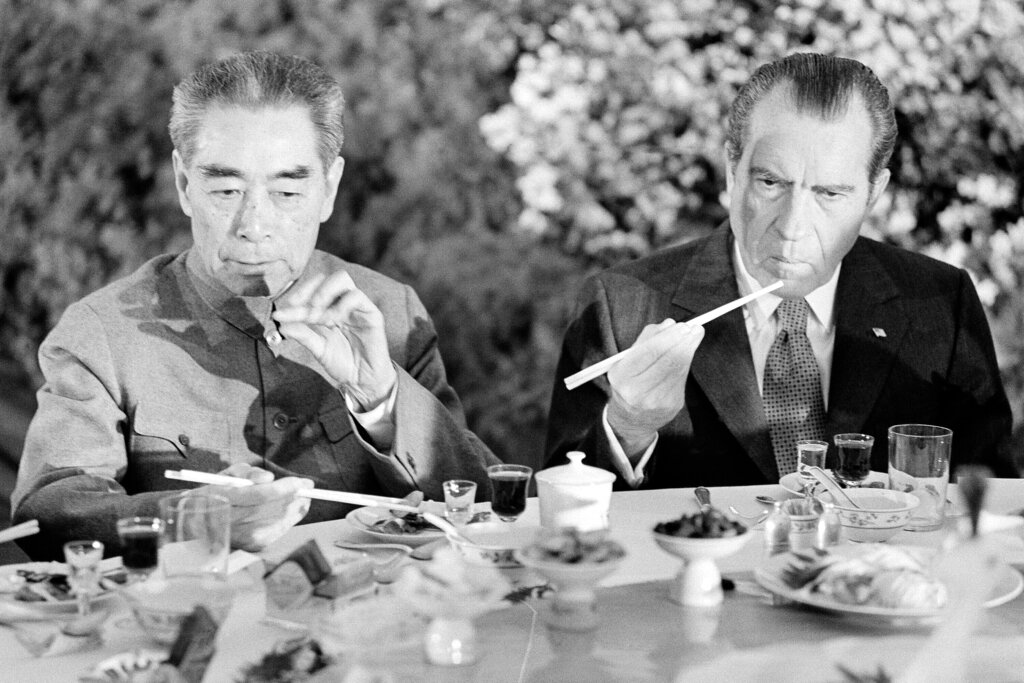 FILE - In this Feb. 28, 1972, file photo, then U.S. President Richard Nixon, right, is serious-faced as he eats with chopsticks with then Chinese Premier Chou En-lai in Shanghai, China. Nixon became the first American president to visit Communist China. (AP Photo, File)