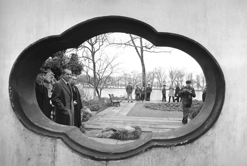 FILE - Framed in the opening of a wall, then U.S. President Richard Nixon and then Chinese Premier Zhou Enlai walks past as they tour Hangzhou in the eastern Chinese province of Zhejiang on Feb. 26, 1972. At the height of the Cold War, U.S. President Richard Nixon flew into communist China's center of power for a visit that over time would transform U.S.-China relations and China's position in the world in ways that were unimaginable at the time. (AP Photo, File)