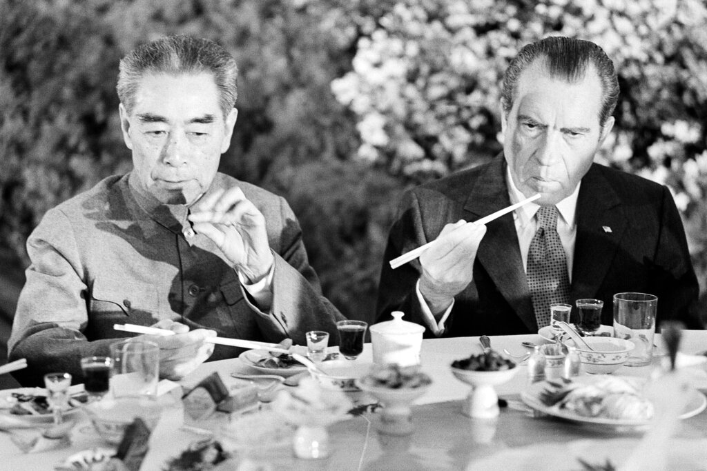 FILE - Then U.S. President Richard Nixon, right, is serious-faced as he eats with chopsticks next to then Chinese Premier Zhou Enlai in Shanghai on February 28, 1972. At the height of the Cold War, U.S. President Richard Nixon flew into communist China's center of power for a visit that over time would transform U.S.-China relations and China's position in the world in ways that were unimaginable at the time. (AP Photo, File)