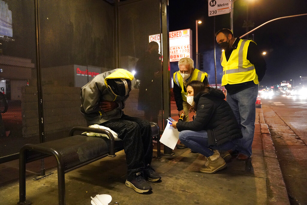 Los Angeles city councilmember Paul Krekorian, third from right, talks to a homeless man during a city-wide count, with members of his staff Lorraine Diaz, kneeling, and Karo Torossian Tuesday, Feb. 22, 2022, in the North Hollywood section of Los Angeles. Los Angeles County has resumed its annual homeless count in full a year after it was limited over concerns that it couldn't be done safely or accurately during the coronavirus pandemic. (AP Photo/Marcio Jose Sanchez)