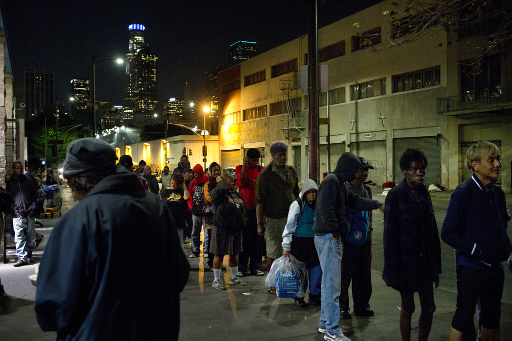 FILE - In this Sept. 19, 2017, file photo, people line up for free food being given out in an area of downtown Los Angeles known as Skid Row. Los Angeles County will resume its annual homeless count in full a year after it was limited over concerns that it couldn't be done safely or accurately during the coronavirus pandemic, officials said Thursday, Jan. 6, 2022. (AP Photo/Jae C. Hong, File)