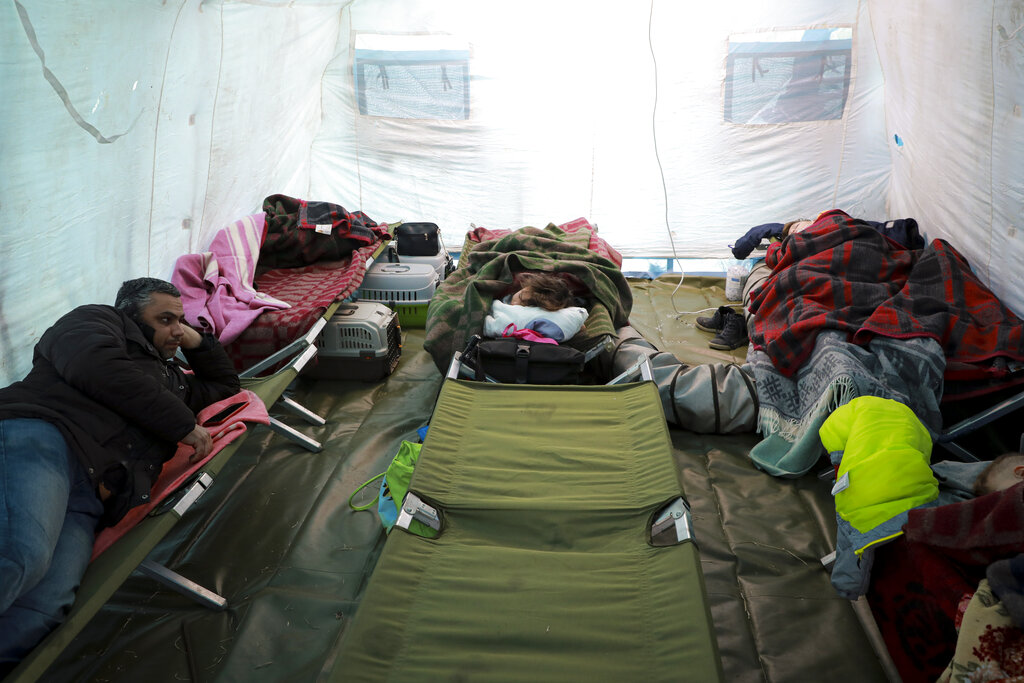 Refugees from Ukraine sleep in a tent part of a humanitarian center at the Moldovan-Ukrainian border, in Palalanca, Moldova, Friday, Feb. 25, 2022. Thousands of Ukrainians are fleeing from war by crossing their borders to the west in search of safety. They left their country as Russia pounded their capital and other cities with airstrikes for a second day on Friday. Cars were backed up for several kilometers (miles) at some border crossings as authorities in Poland, Slovakia, Hungary, Romania and Moldova mobilized to receive them, offering them shelter, food and legal help (AP Photo/Aurel Obreja)
