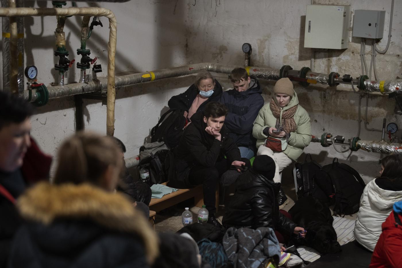 People take shelter at a building basement while the sirens sound announcing new attacks in the city of Kyiv, Ukraine, Friday, Feb. 25, 2022. (AP Photo/Emilio Morenatti)