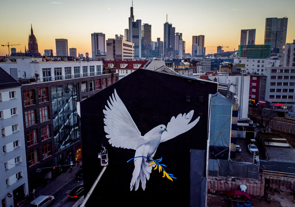 A peace mural showing a dove with a branch in Ukrainian colors by artist Justus Becker is painted on the wall of a house in Frankfurt, Germany, Monday, Feb. 28, 2022. (AP Photo/Michael Probst)