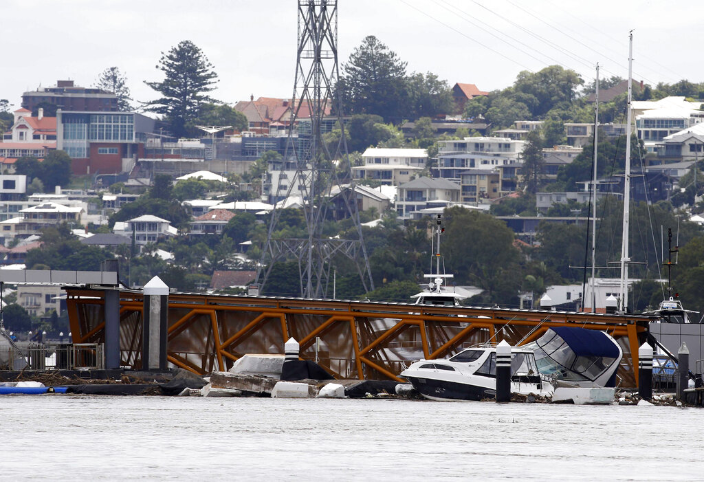 Wreckage and debris litters a jetty on the river in Brisbane, Australia, Wednesday, March 2, 2022. Tens of thousands of people had been ordered to evacuate their homes and many more had been told to prepare to flee as parts of Australia's southeast coast are inundated by the worst flooding in decades. (AP Photo/Tertius Pickard)