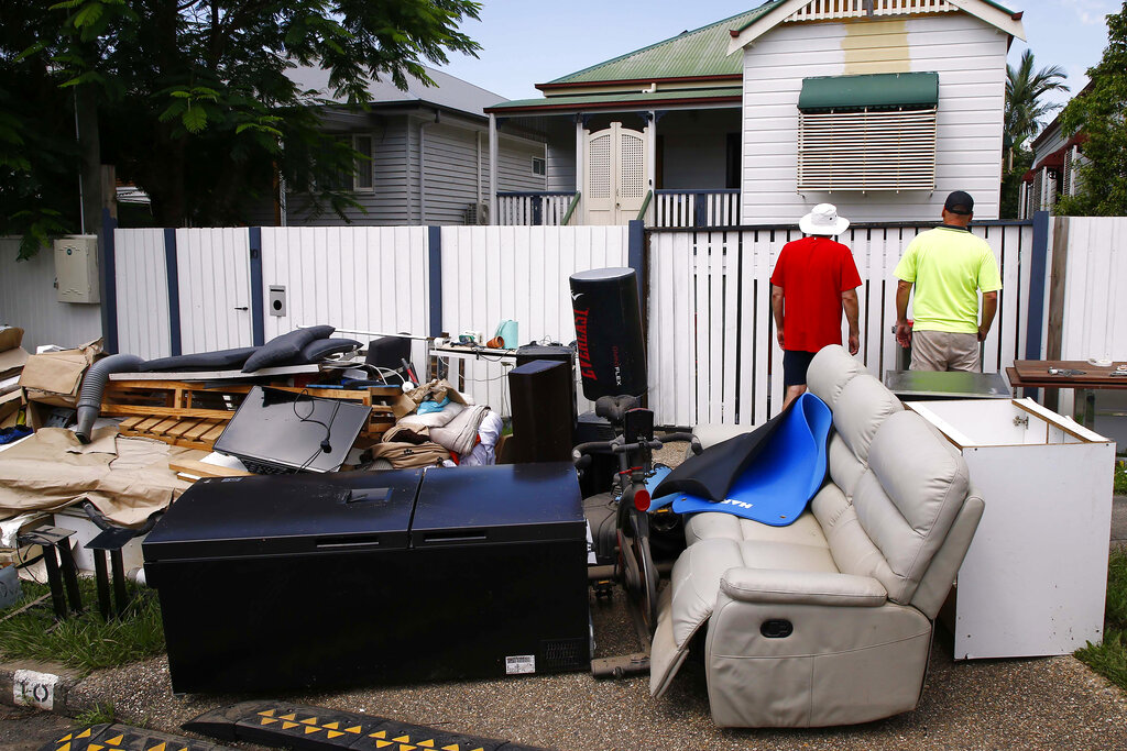 Homeowners inspect the flood damage to their homes in Brisbane, Australia, Wednesday, March 2, 2022. Tens of thousands of people had been ordered to evacuate their homes and many more had been told to prepare to flee as parts of Australia's southeast coast are inundated by the worst flooding in decades. (AP Photo/Tertius Pickard)