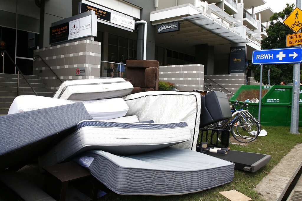 Wet furniture is piled up outside a hotel that flooded in Brisbane, Australia, Wednesday, March 2, 2022. Tens of thousands of people had been ordered to evacuate their homes and many more had been told to prepare to flee as parts of Australia's southeast coast are inundated by the worst flooding in decades. (AP Photo/Tertius Pickard)