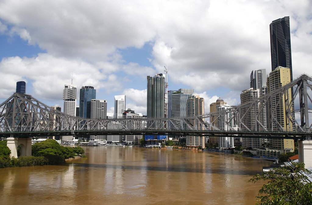 Floodwaters continue to flow down the Brisbane river in Brisbane, Australia, Wednesday, March 2, 2022. Tens of thousands of people had been ordered to evacuate their homes and many more had been told to prepare to flee as parts of Australia's southeast coast are inundated by the worst flooding in decades. (AP Photo/Tertius Pickard)