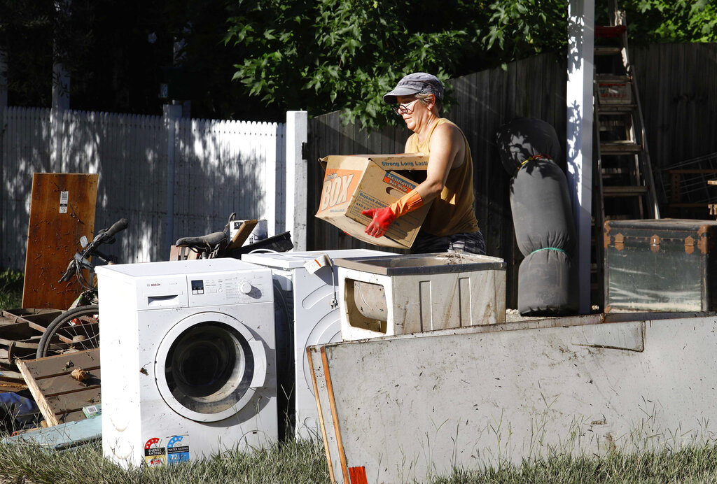 A resident cleans up wreckage from their flooded homes in Brisbane, Australia, Tuesday, March 1, 2022. Tens of thousands of people had been ordered to evacuate their homes and many more had been told to prepare to flee as parts of Australia's southeast coast are inundated by the worst flooding in decades. (AP Photo/Tertius Pickard)