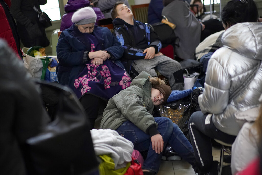 People who fled the war from neighboring Ukraine sleep at the Przemysl train station in Przemysl, Poland, Wednesday, March 9, 2022. (AP Photo/Daniel Cole)