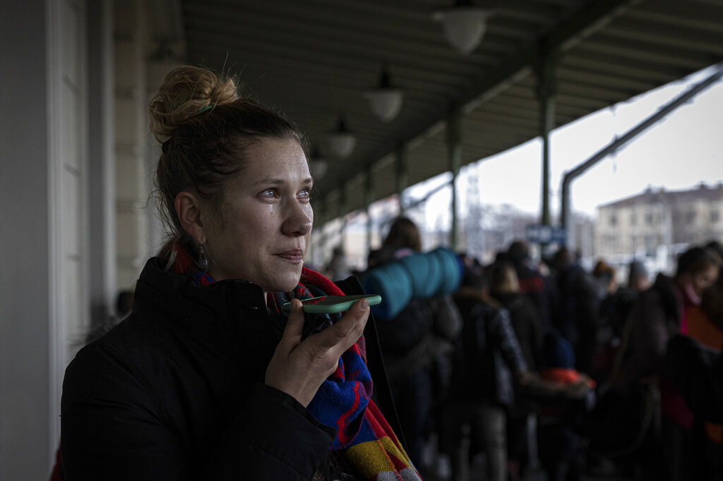 A woman from Kyiv, Ukraine calls her family after arriving at the train station in Przemysl, Poland, Wednesday March 2, 2022. The number of Ukrainians forced from their country since the Russian invasion has been increasing on a daily basis. (AP Photo/Marc Sanye)