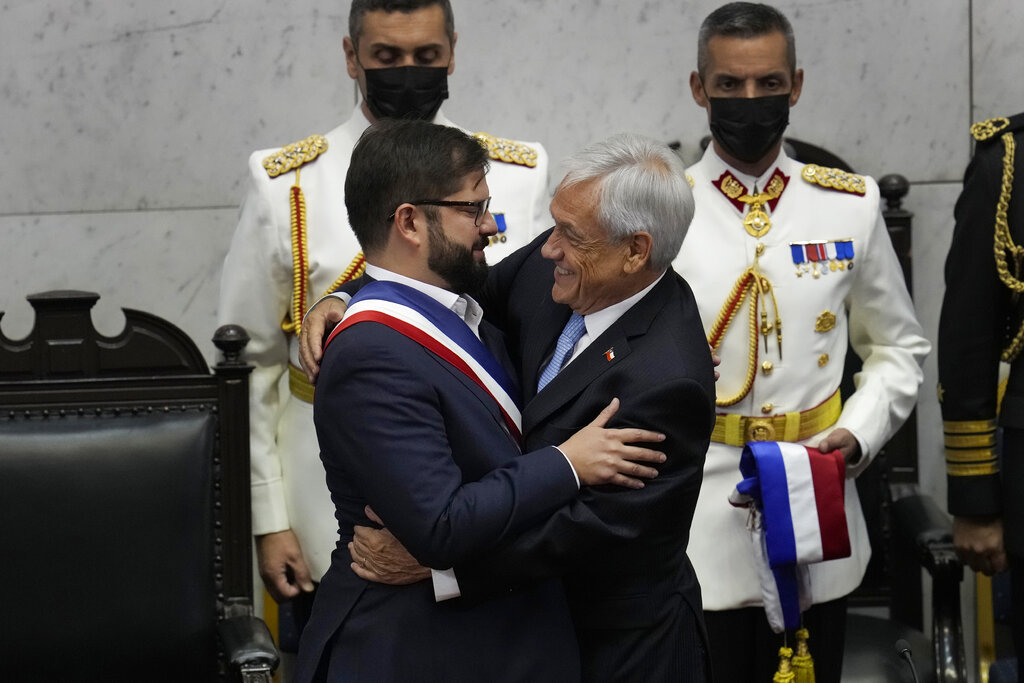 Chile's new President Gabriel Boric, left, is embraced by outgoing President Sebastian Pinera during Boric's swearing-in ceremony at Congress in Valparaiso, Chile, Friday, March 11, 2022. (AP Photo/Esteban Felix)