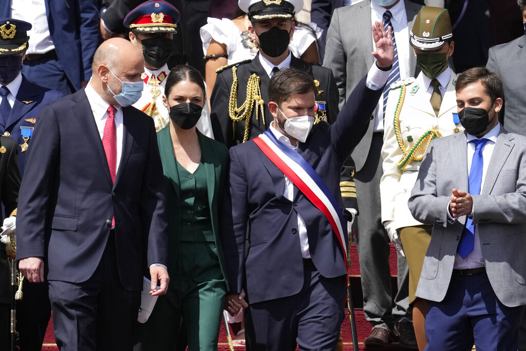 Chile's new President Gabriel Boric, holding hands with his partner Irina Karamanos, waves after his swearing-in ceremony at Congress in Valparaiso, Chile, Friday, March 11, 2022. (AP Photo/Natacha Pisarenko)