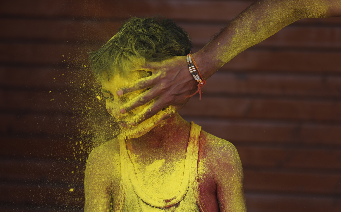 A reveller smears colored powder on a boy as they celebrate Holi in Prayagraj, in the northern Indian state of Uttar Pradesh, India, India, Friday, March 18, 2022. The festival, a celebration of warm weather, good harvests and the defeat of evil, brings out millions of people, from toddlers to the elderly, to throw powder at one another and play with water balloons and squirt guns. (AP Photo/Rajesh Kumar Singh)