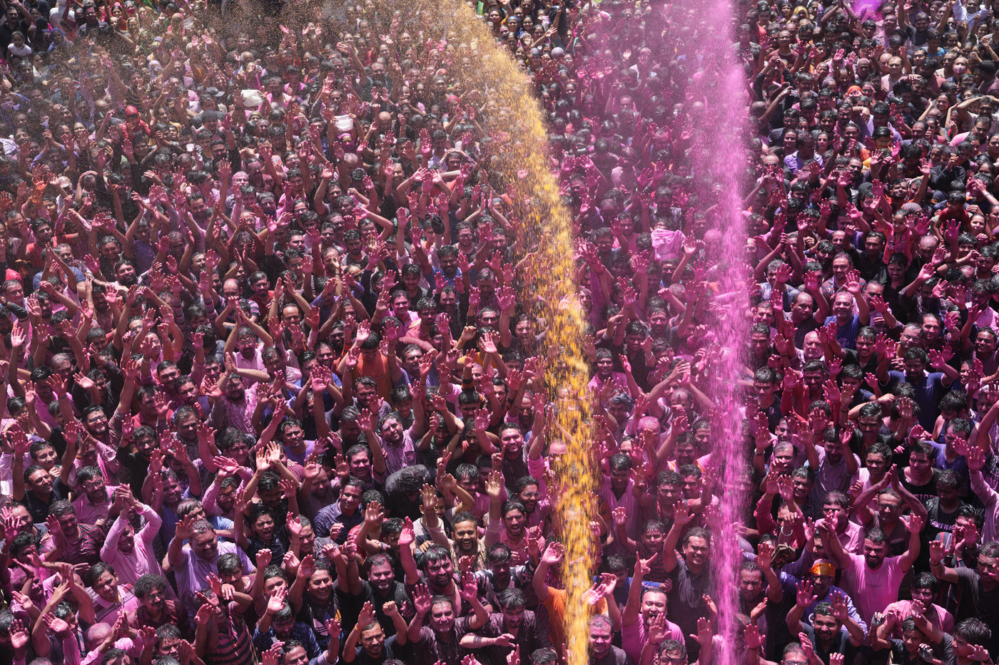Devotees cheer as colored powder and water is sprayed on them during celebrations marking Holi at the Kalupur Swaminarayan temple in Ahmedabad, India, Friday, March 18, 2022. Holi, the Hindu festival of colors, also marks the advent of spring. (AP Photo/Ajit Solanki)