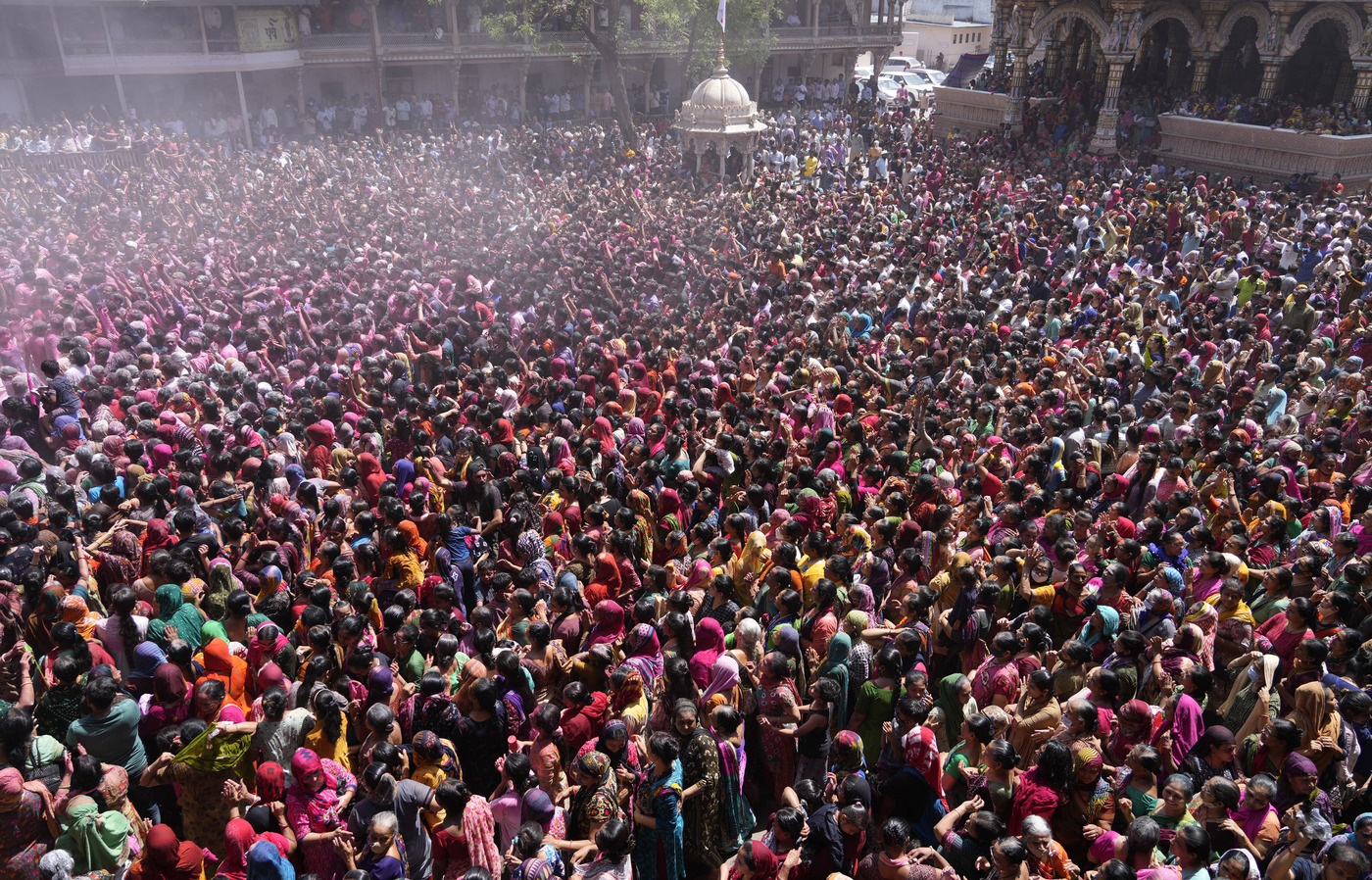 Devotees cheer as colored powder and water is sprayed on them during celebrations marking Holi at the Kalupur Swaminarayan temple in Ahmedabad, India, Friday, March 18, 2022. Holi, the Hindu festival of colors, also marks the advent of spring. (AP Photo/Ajit Solanki)