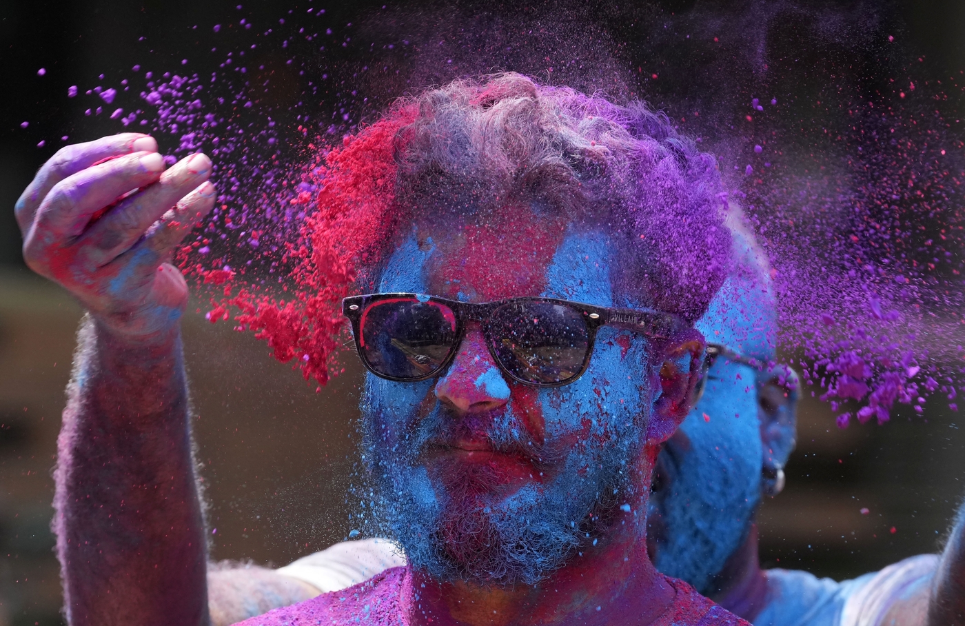Colored powder is thrown on a reveller during celebrations marking Holi, the Hindu festival of colors, in Mumbai, India, Friday, March 18, 2022. (AP Photo/ Rajanish Kakade)