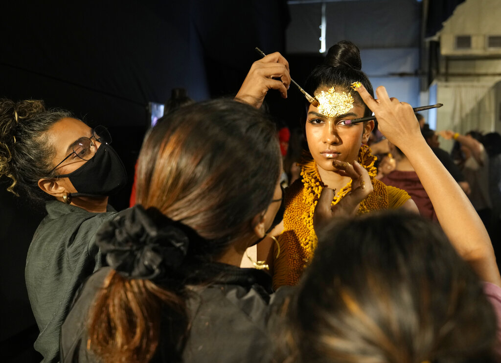 Makeup artists give last minute touches to a model backstage during the 'FDCI X Lakme Fashion Week' in New Delhi, Thursday, March 24, 2022. (AP Photo/Manish Swarup)