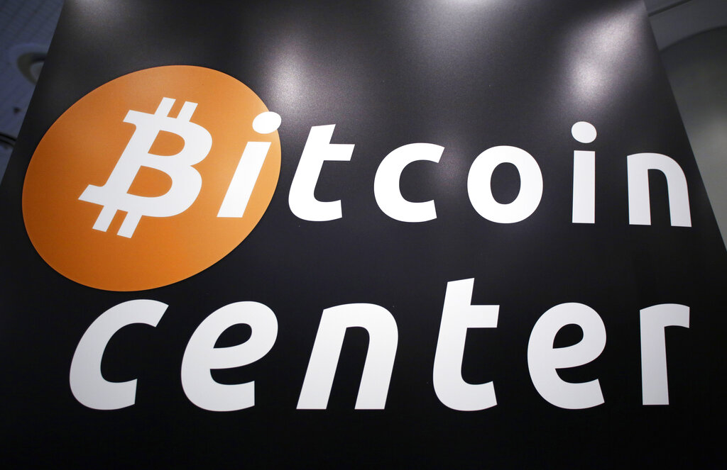 A sign for the Bitcoin Center New York City, located in the city's financial district, is displayed at the Inside Bitcoins conference and trade show, Monday, April 7, 2014 in New York. (AP Photo/Mark Lennihan)