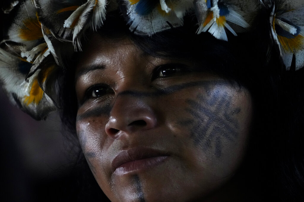 A Tembe Indigenous woman attends a ceremony called the Meeting of the First Peoples at the 18th annual Free Land Indigenous Camp in Brasilia, Brazil, Friday, April 8, 2022. The 10-day event aims to show the unity of Brazil's Indigenous peoples in their fight for the demarcation of their lands and their rights. (AP Photo/Eraldo Peres)