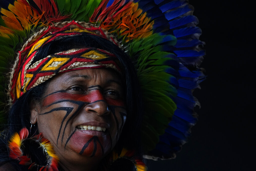 A Pataxo Indigenous woman attends a ceremony called the Meeting of the First Peoples at the 18th annual Free Land Indigenous Camp in Brasilia, Brazil, Friday, April 8, 2022. The 10-day event aims to show the unity of Brazil's Indigenous peoples in their fight for the demarcation of their lands and their rights. (AP Photo/Eraldo Peres)