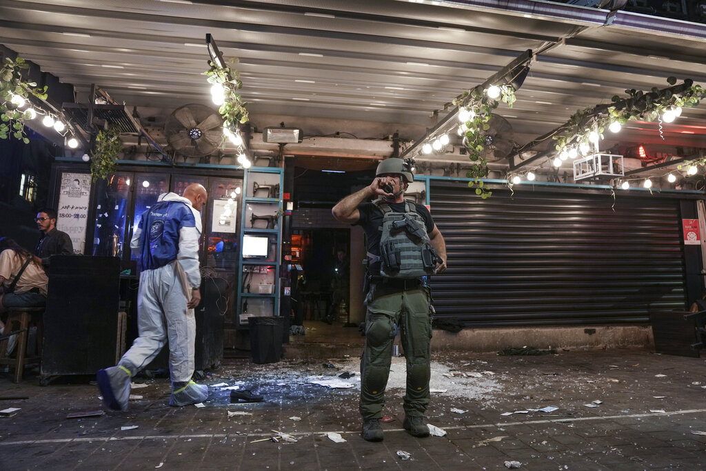 Israeli police inspect the scene of a shooting attack In Tel Aviv, Israel, Thursday, April 7, 2022. Israeli police say several people were wounded in a shooting in central Tel Aviv. The shooting on Thursday evening occurred in a crowded area with several bars and restaurants. (AP Photo/Ariel Schalit)