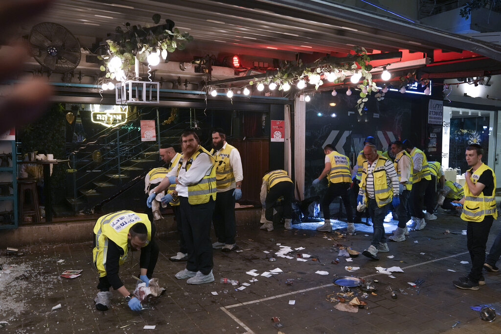 Members of Israeli Zaka Rescue and Recovery team clean blood from the site of a shooting attack In Tel Aviv, Israel, Thursday, April 7, 2022. Israeli health officials say two people were killed and at least eight others wounded in a shooting in central Tel Aviv. The shooting on Thursday evening, the fourth attack in recent weeks, occurred in a crowded area with several bars and restaurants. (AP Photo/Ariel Schalit)