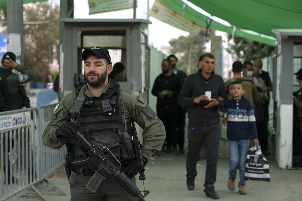 An Israeli Border Police officer secures a checkpoint from the West Bank town of Bethlehem into Jerusalem as Palestinians cross for the first Friday prayers in the Muslim holy month of Ramadan at the Al Aqsa mosque compound in Jerusalem's Old City, Friday, April 8, 2022. (AP Photo/Maya Alleruzzo)