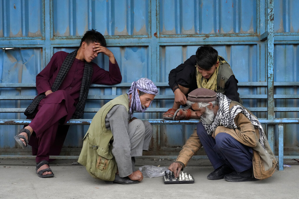 Afghan men play chess on a sidewalk in Kabul, Afghanistan, Monday, April 18, 2022. (AP Photo/Ebrahim Noroozi)